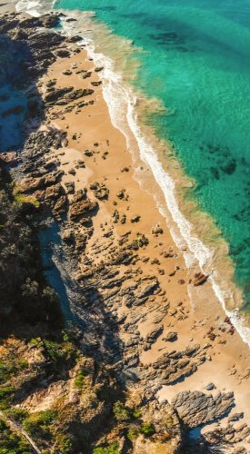 A generic sea shore or beach image taken like a drone shot high above from sky to potray the serene and calm nature and environment which is tranquil.