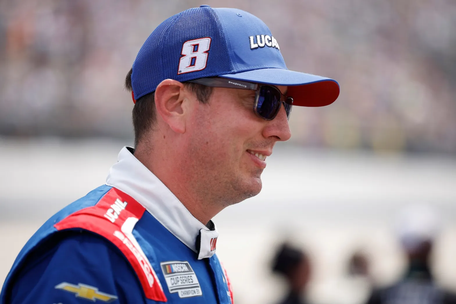 A dramatic NASCAR-themed thumbnail showing Kyle Busch beside a racing car with dark tones, emotional lighting, and bold text questioning the cause of his sudden death.
