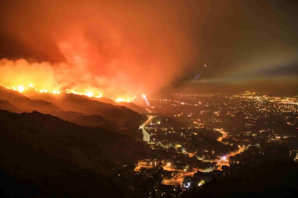 Massive wildfire spreading across dry hills near Simi Valley as thick smoke fills the sky while emergency crews battle flames threatening homes.