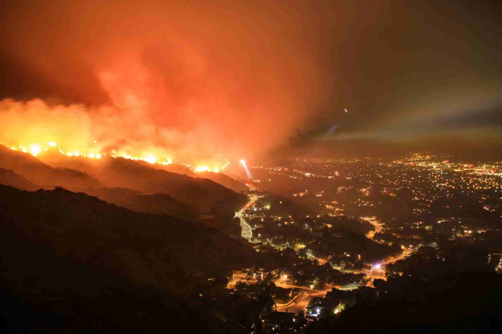 Massive wildfire spreading across dry hills near Simi Valley as thick smoke fills the sky while emergency crews battle flames threatening homes.